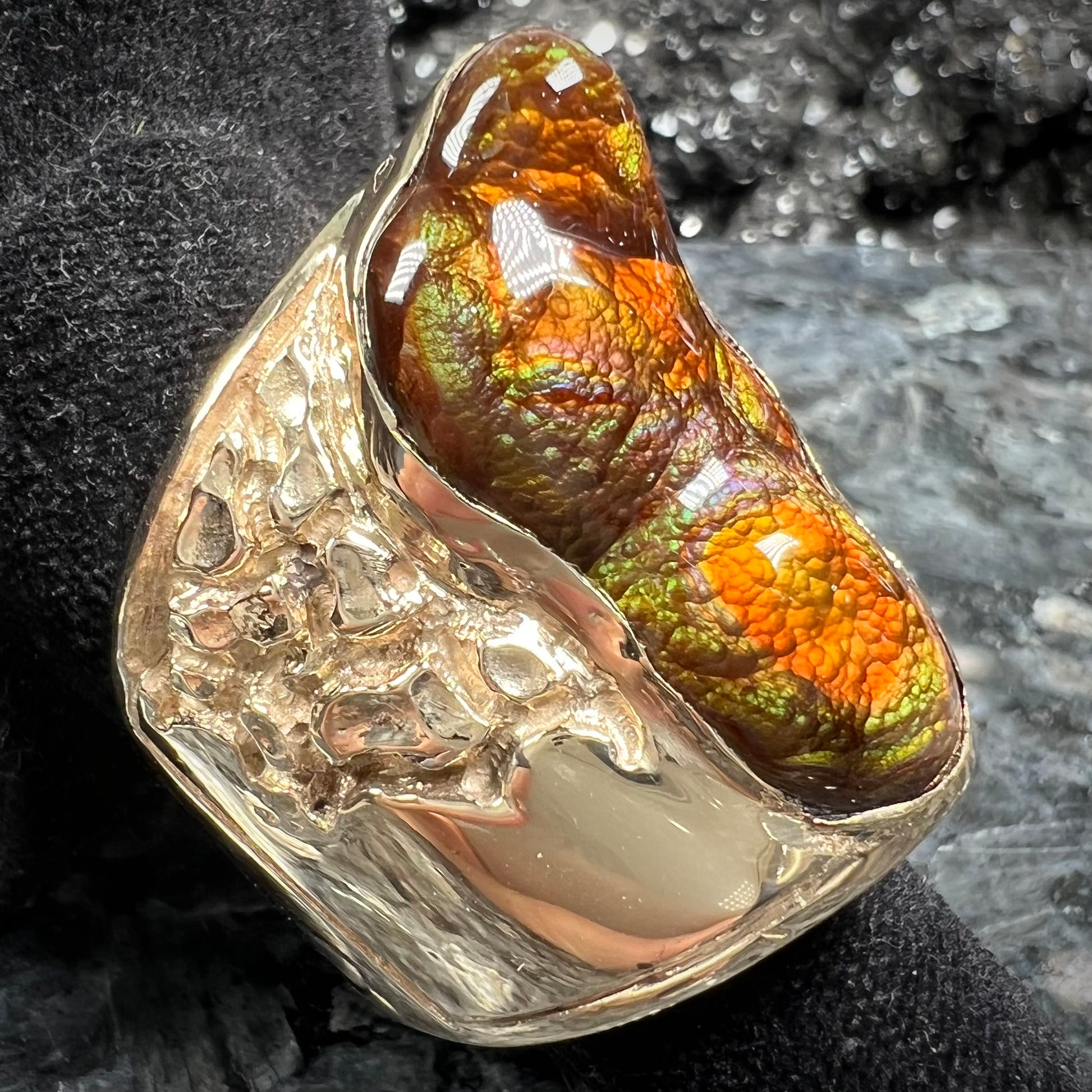 A large nugget style men's fire agate ring cast in yellow gold.  The fire agate is predominantly orange and green.