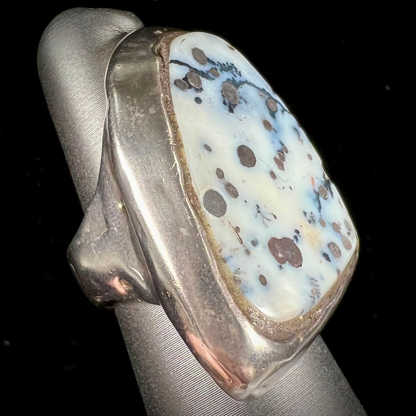 A bezel set ring handmade in sterling silver with a white dendritic agate stone.