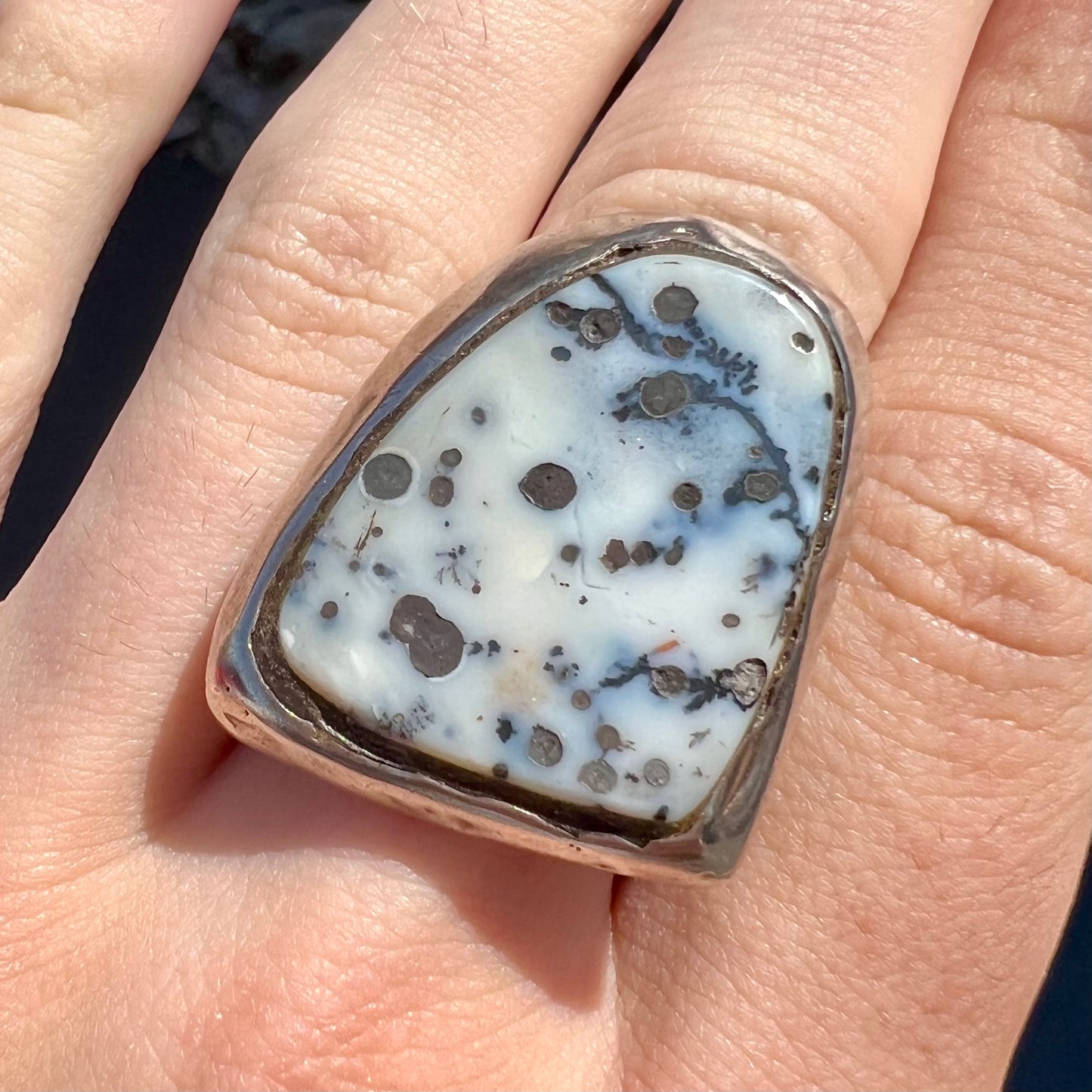 A bezel set ring handmade in sterling silver with a white dendritic agate stone.