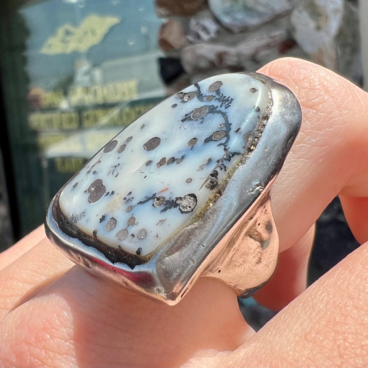 A bezel set ring handmade in sterling silver with a white dendritic agate stone.