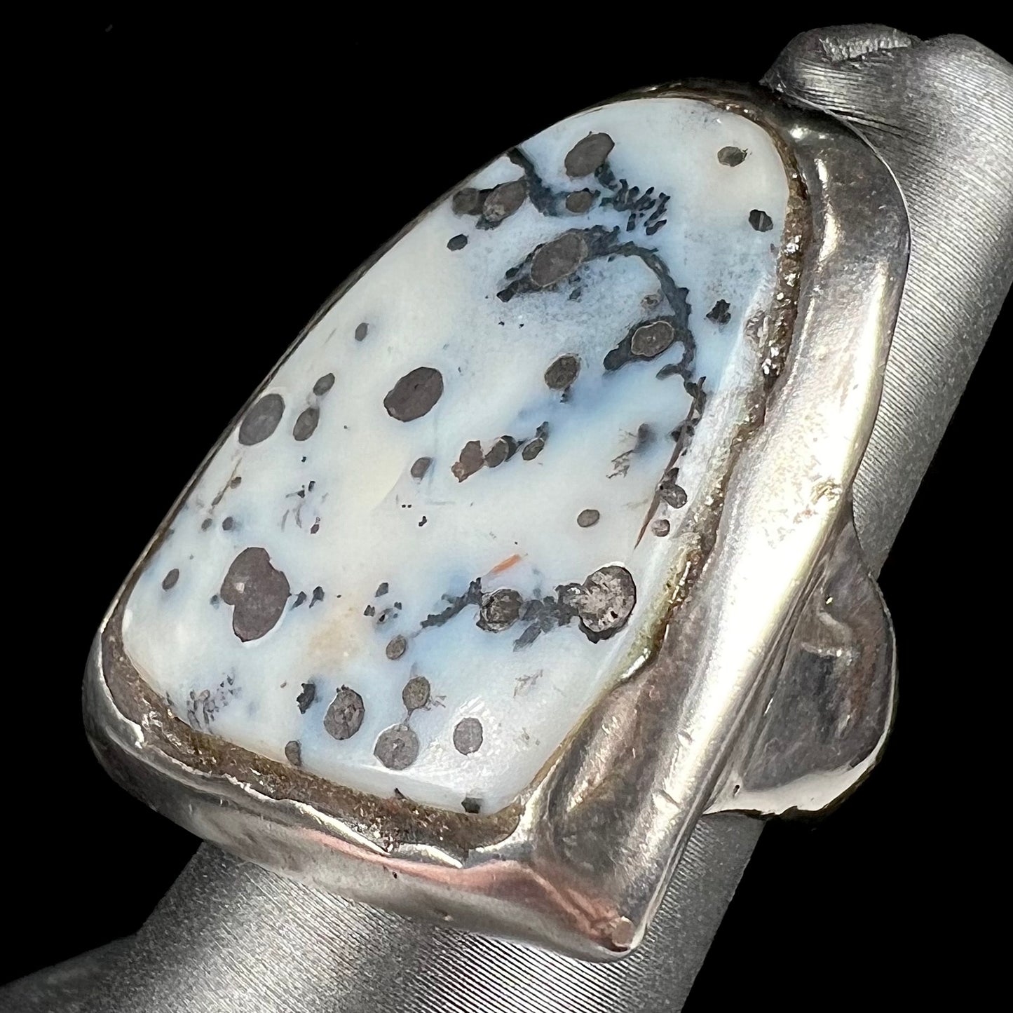 A bezel set ring handmade in sterling silver with a white dendritic agate stone.