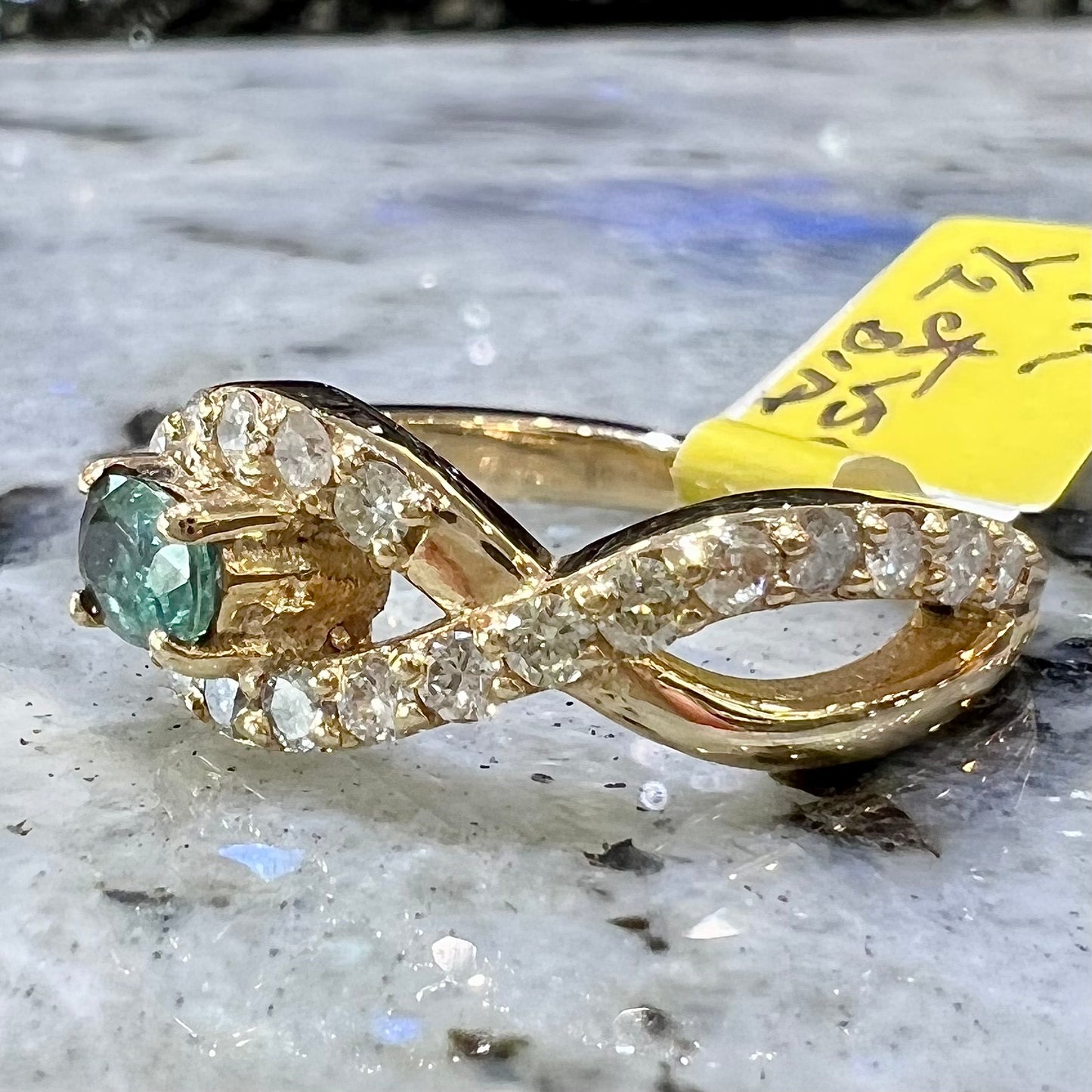 Yellow gold alexandrite and pave set diamond ladies' ring on ring stand.
