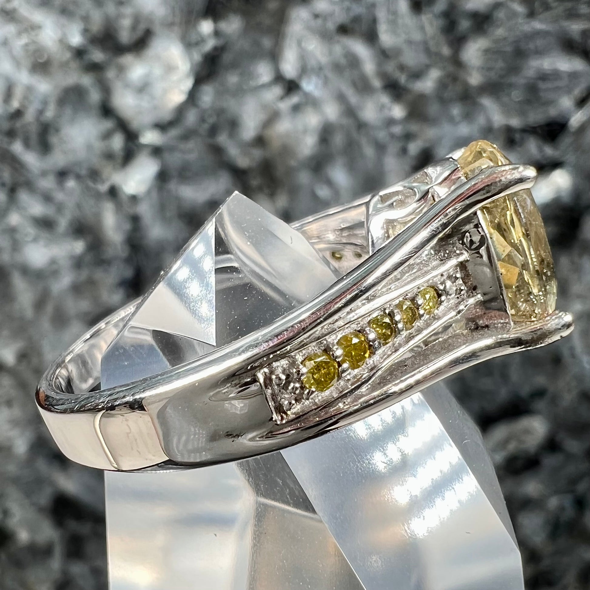 A sterling silver oval cut citrine ring set with canary yellow diamond accents.
