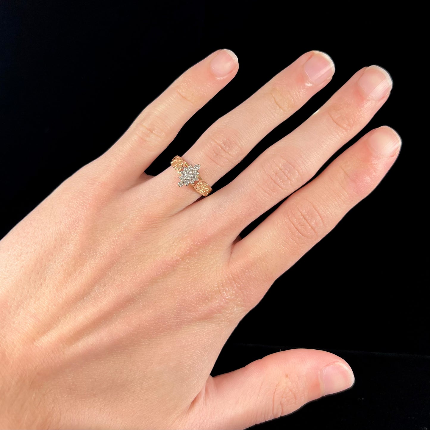A ladies' estate diamond cluster ring cast in yellow gold. The shank has a nugget design.