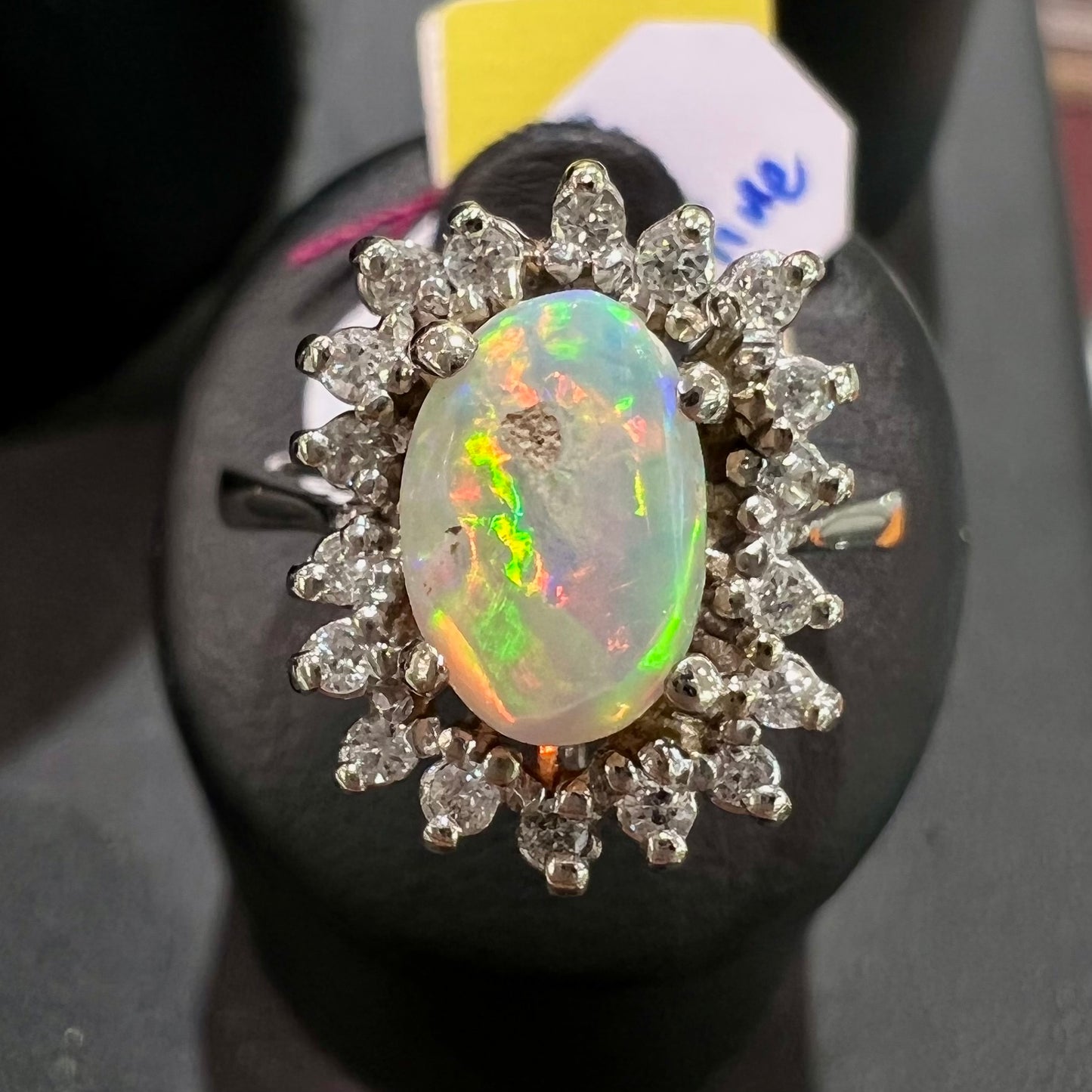 A white crystal opal ring cast in white gold with a halo of round cut diamonds.