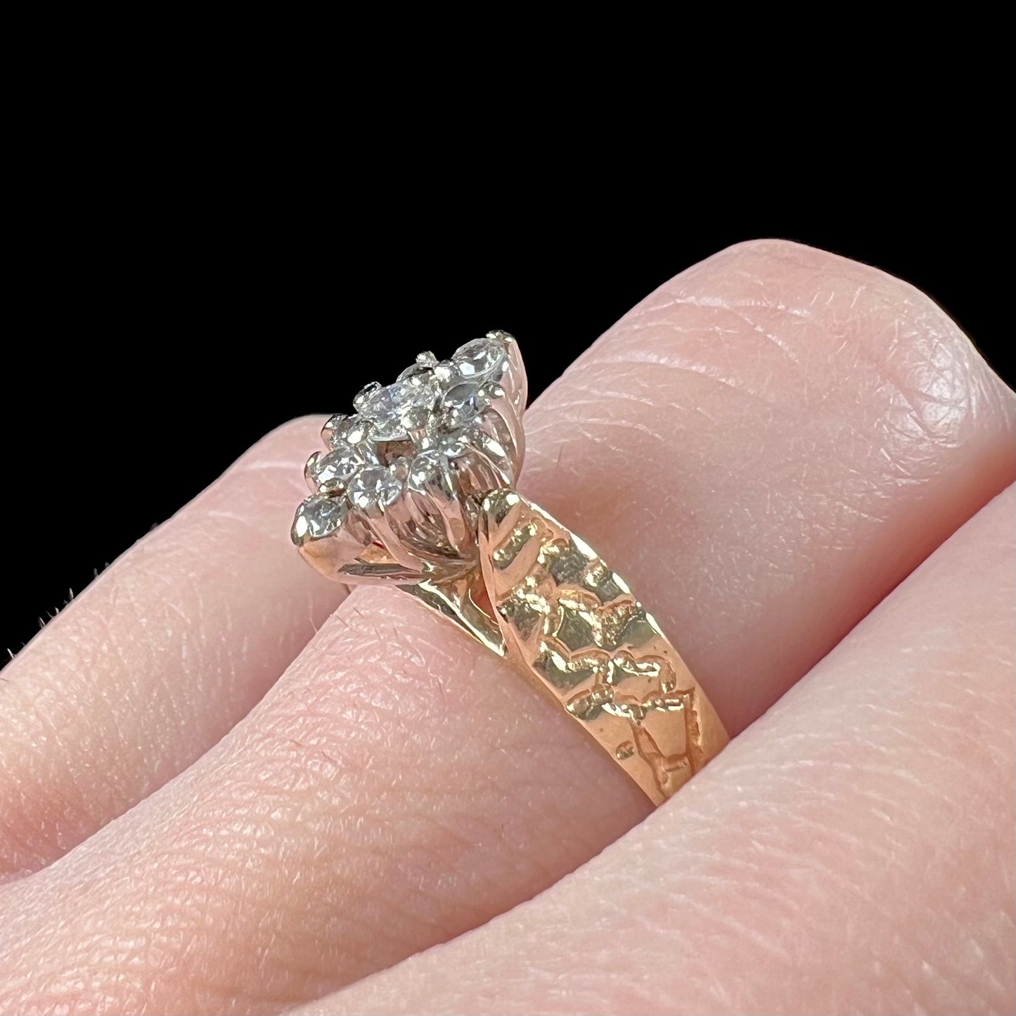 A ladies' estate diamond cluster ring cast in yellow gold. The shank has a nugget design.