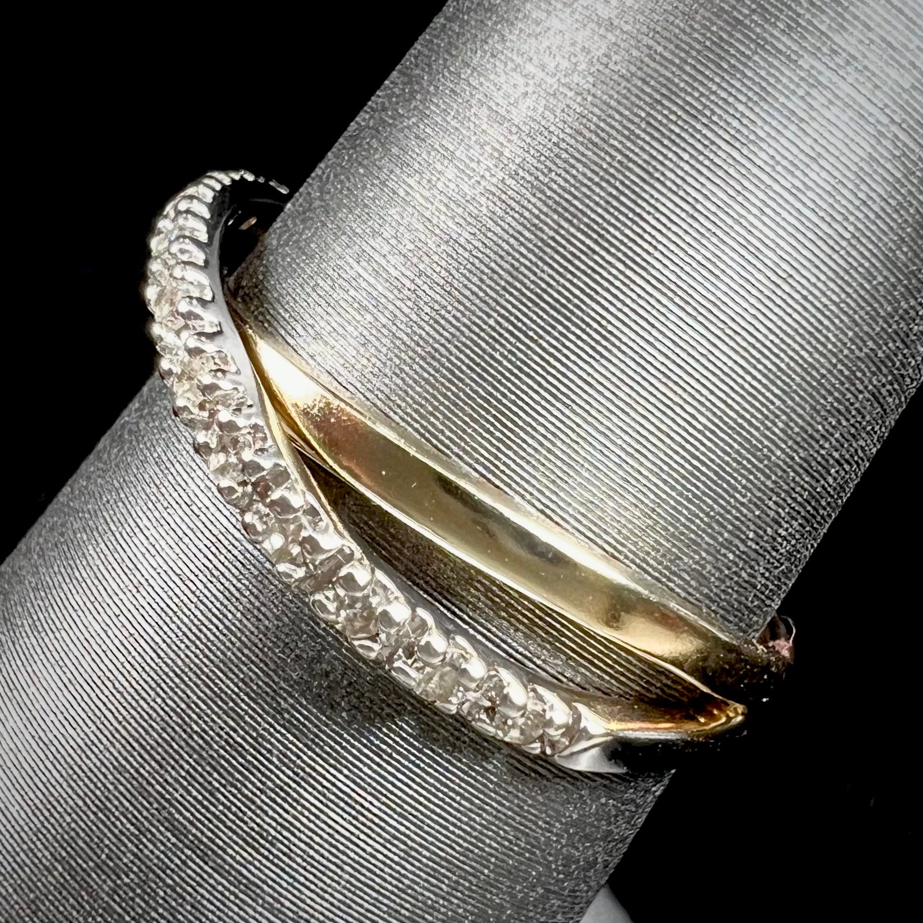 A ladies' two tone yellow and white gold twisted shank ring pave set with round single cut diamonds.