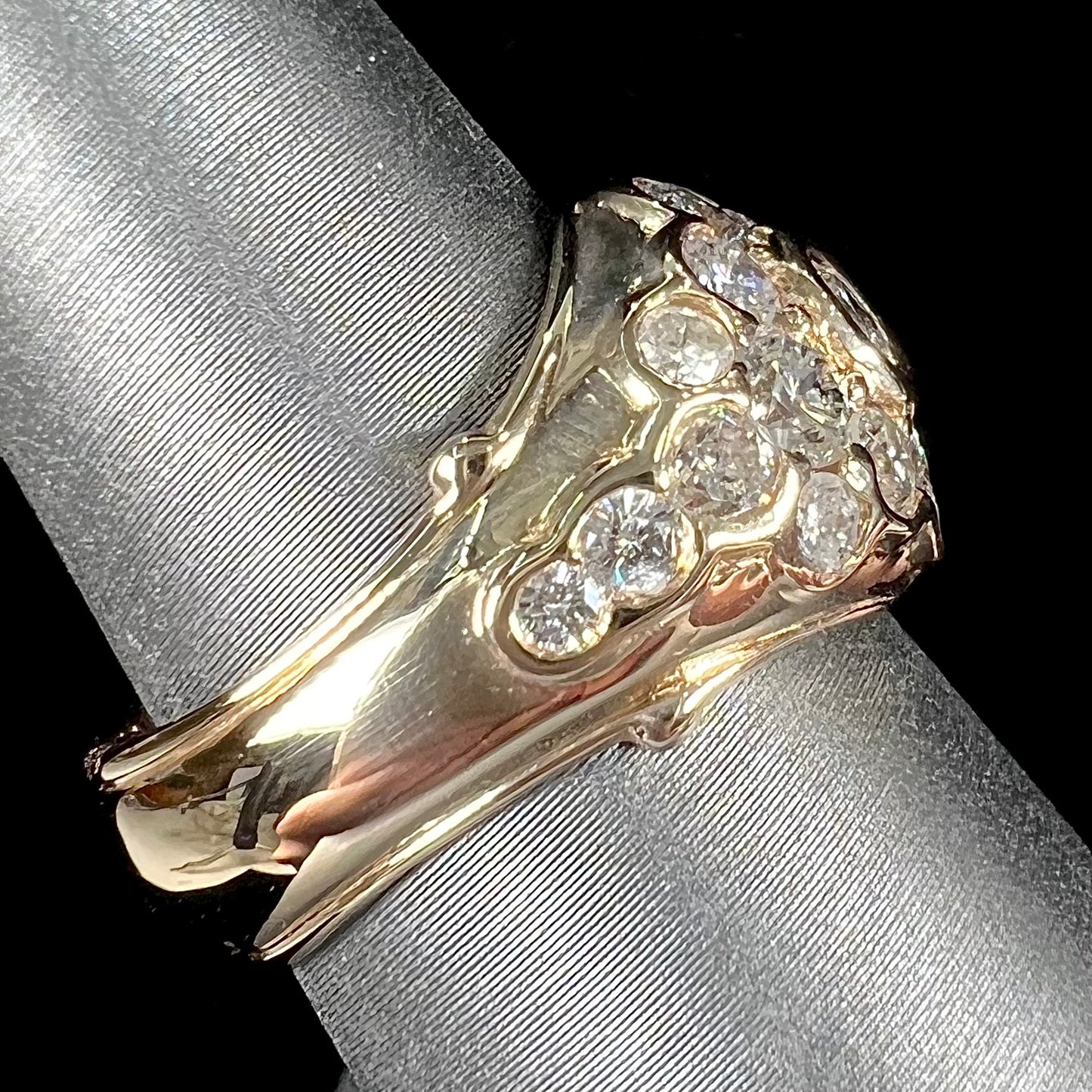 A yellow gold domed diamond ring set with 19 Standard Round Brilliant Cut diamonds.