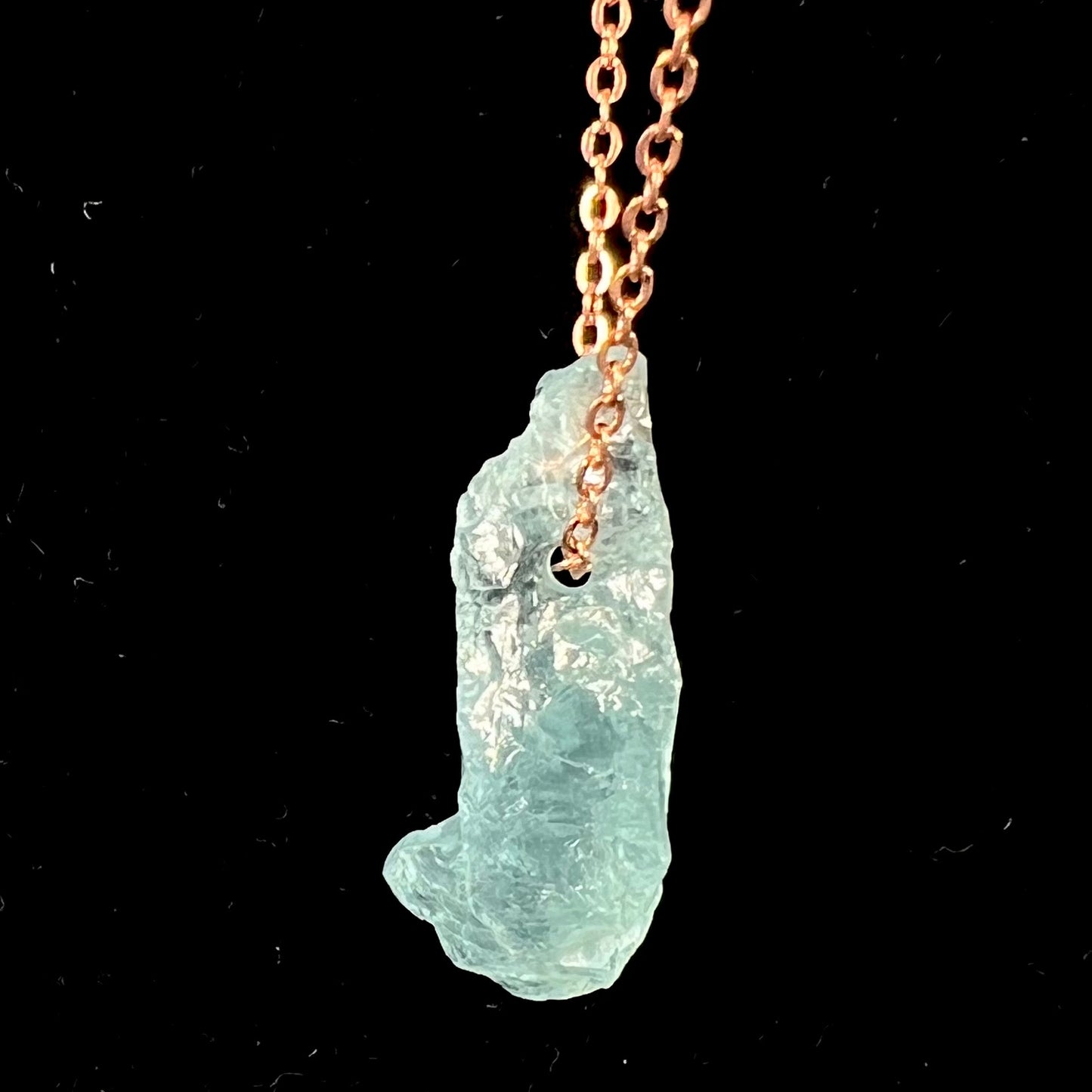 A drilled aquamarine crystal necklace on a copper cable chain.