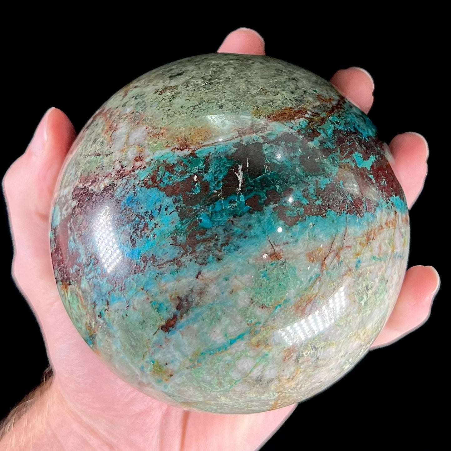 A stone sphere cut from Eilat Stone, mined in Israel. Material contains turquoise, chrysocolla, azurite, malachite, and cuprite.