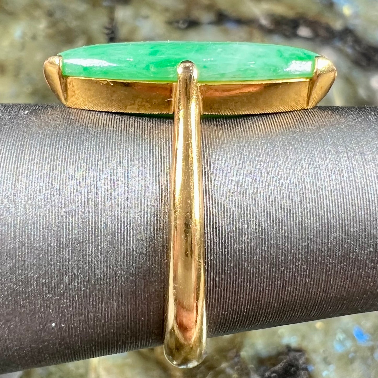 A 22 karat yellow gold solitaire ring set with a marquise cabochon cut green jadeite.