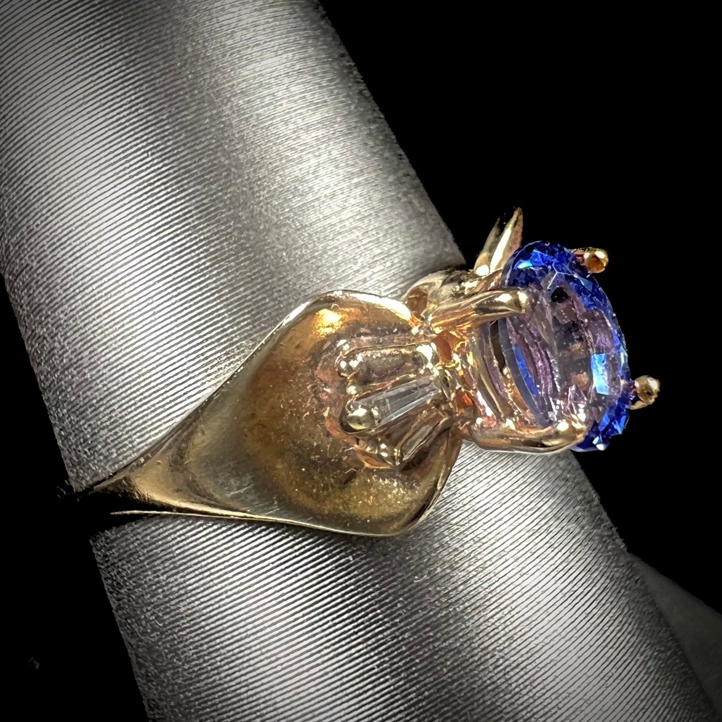 A natural blue sapphire and diamond baguette ring cast in yellow gold.