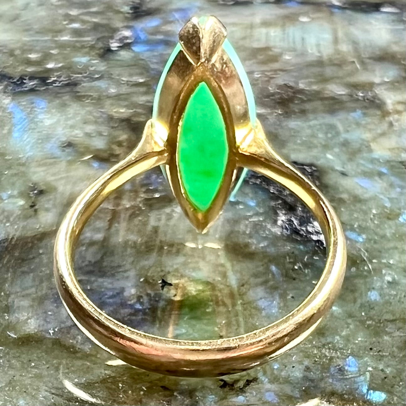 A 22 karat yellow gold solitaire ring set with a marquise cabochon cut green jadeite.