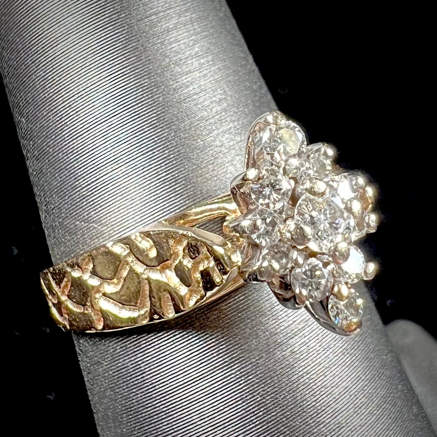 A ladies' estate diamond cluster ring cast in yellow gold. The shank has a nugget design.