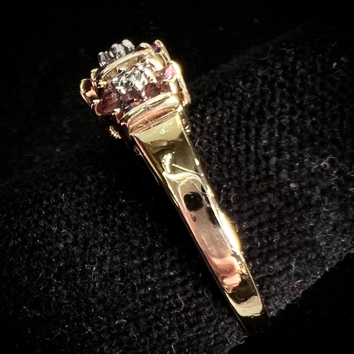 A vintage ladies' flower ring set with set with amethyst and pink tourmaline petals with a diamond center stone.