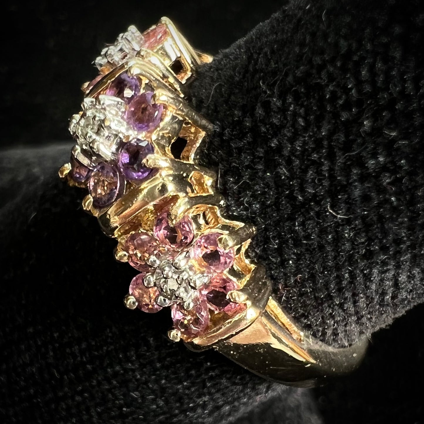 A vintage ladies' flower ring set with set with amethyst and pink tourmaline petals with a diamond center stone.
