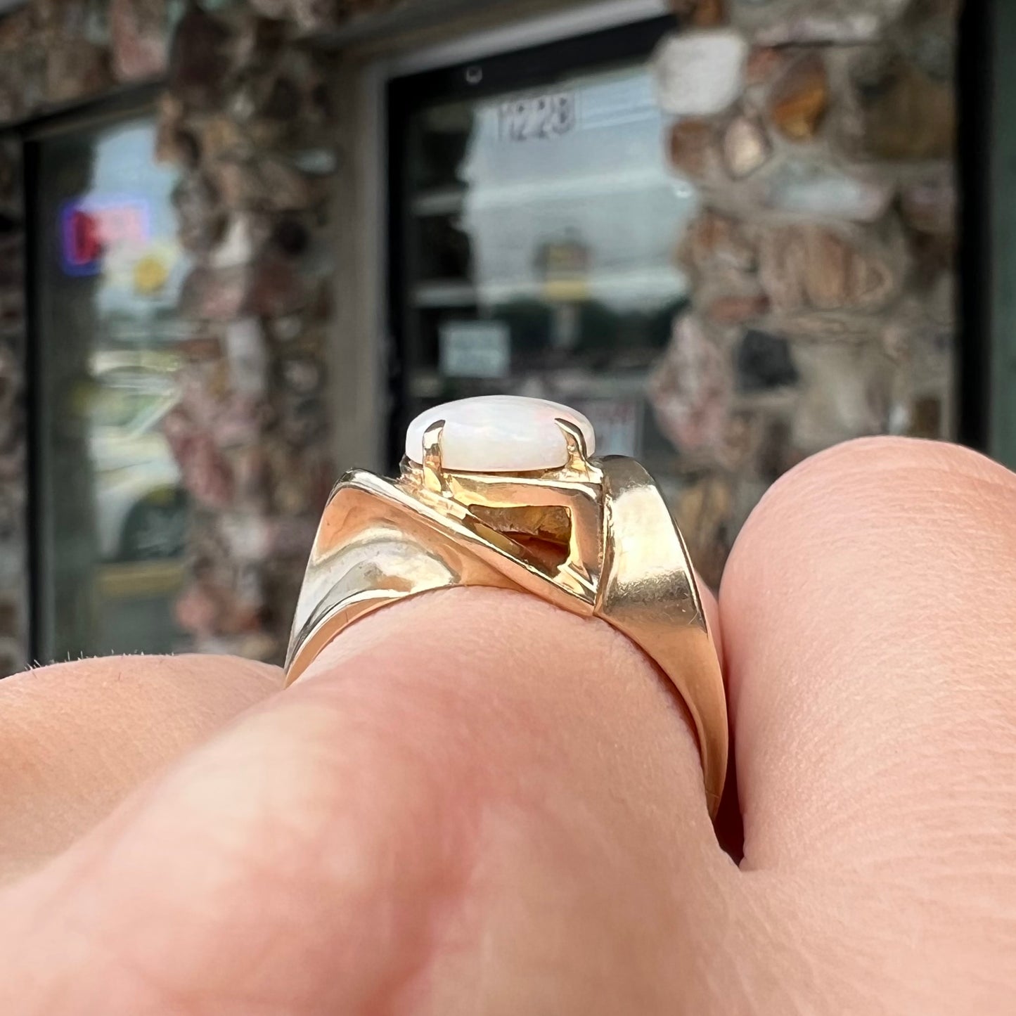An estate gold white crystal opal solitaire ring. There are some scratches on the gold.