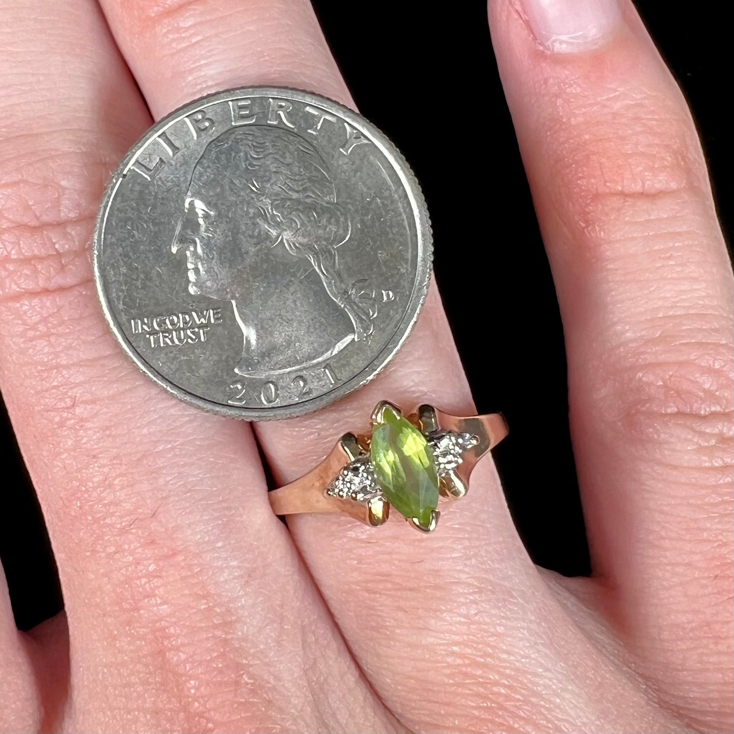 A ladies' marquise cut peridot and diamond ring in 10 karat yellow gold.