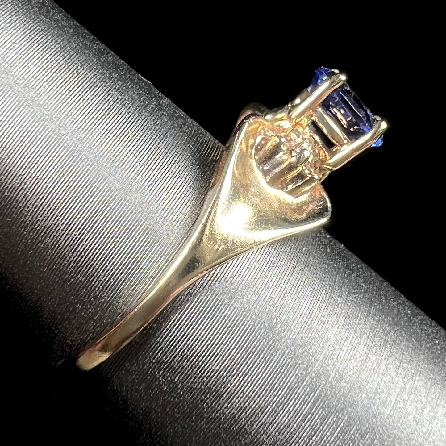 A natural blue sapphire and diamond baguette ring cast in yellow gold.