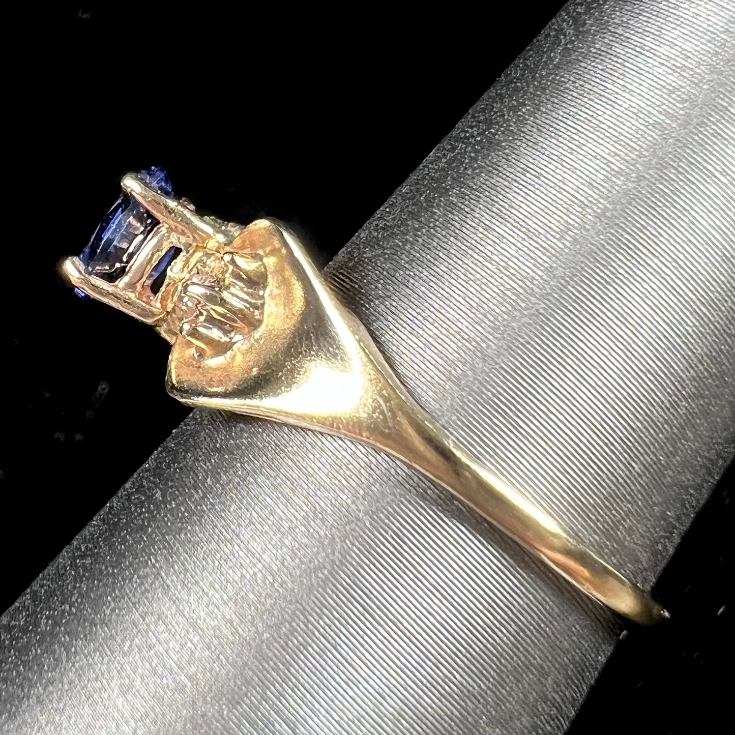 A natural blue sapphire and diamond baguette ring cast in yellow gold.
