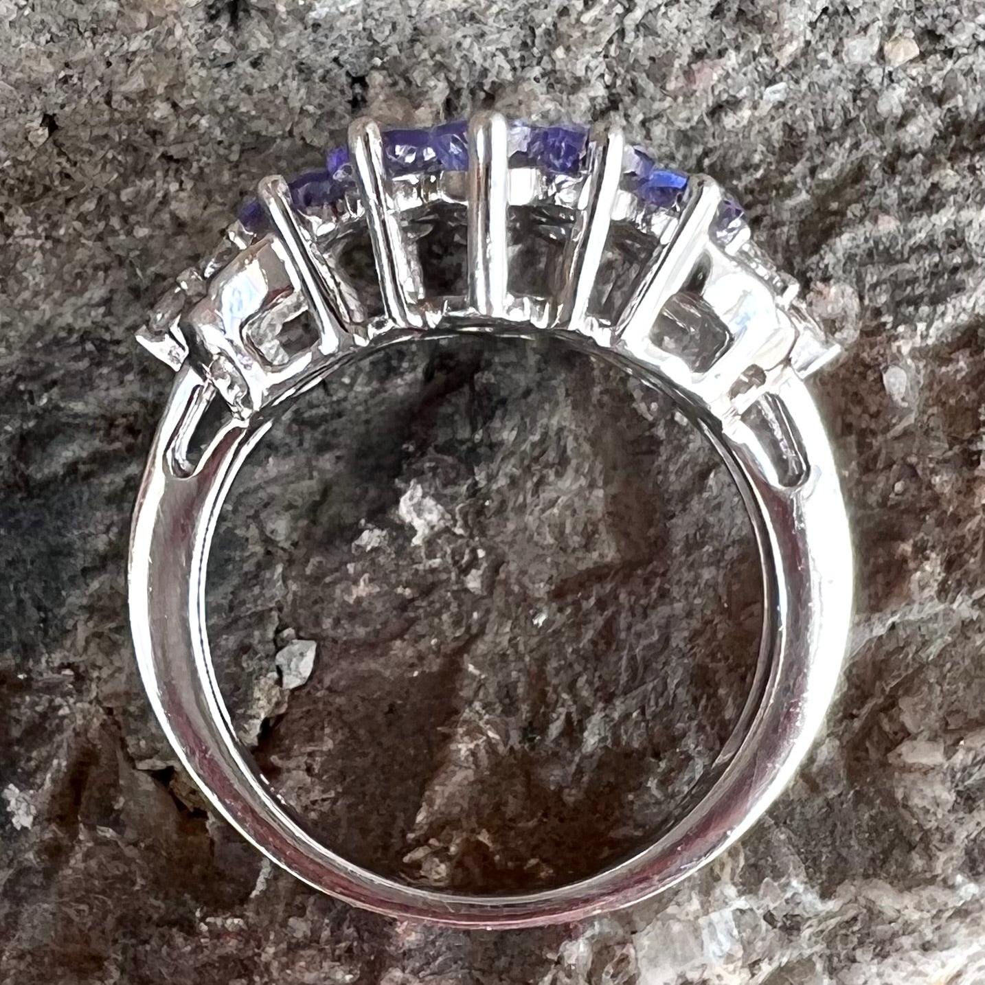 A sterling silver gemstone cluster ring set with oval cut tanzanite stones and round cubic zirconia accents.