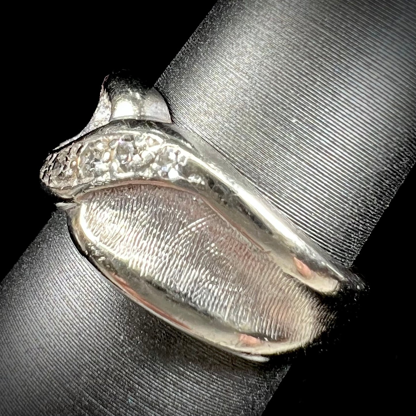 A ladies' white gold five stone single cut diamond ring.  The metal of the ring has a textured finish.