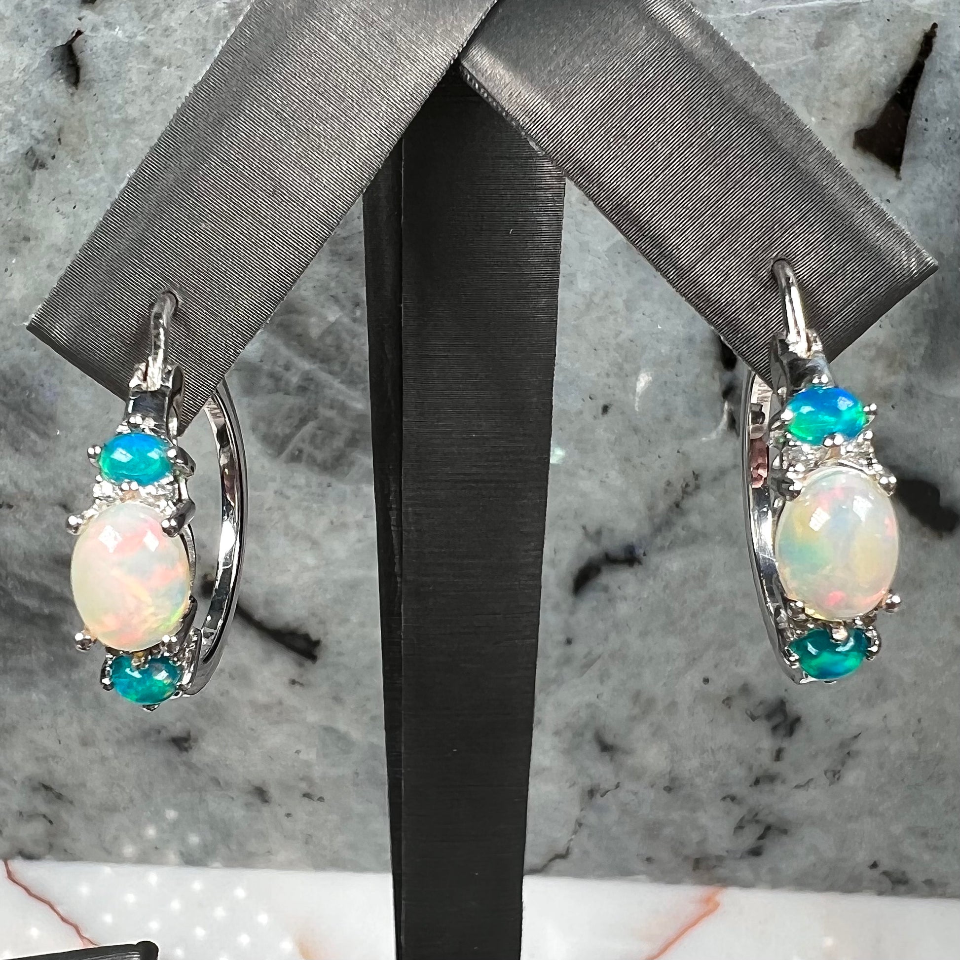 A sterling silver ring, earring, and necklace set made of Ethiopian opals and cubic zirconia.