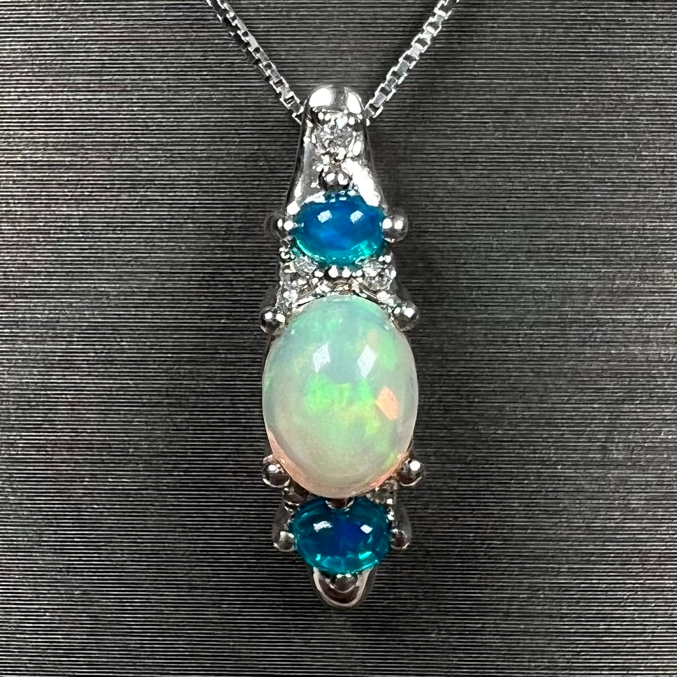 A sterling silver ring, earring, and necklace set made of Ethiopian opals and cubic zirconia.