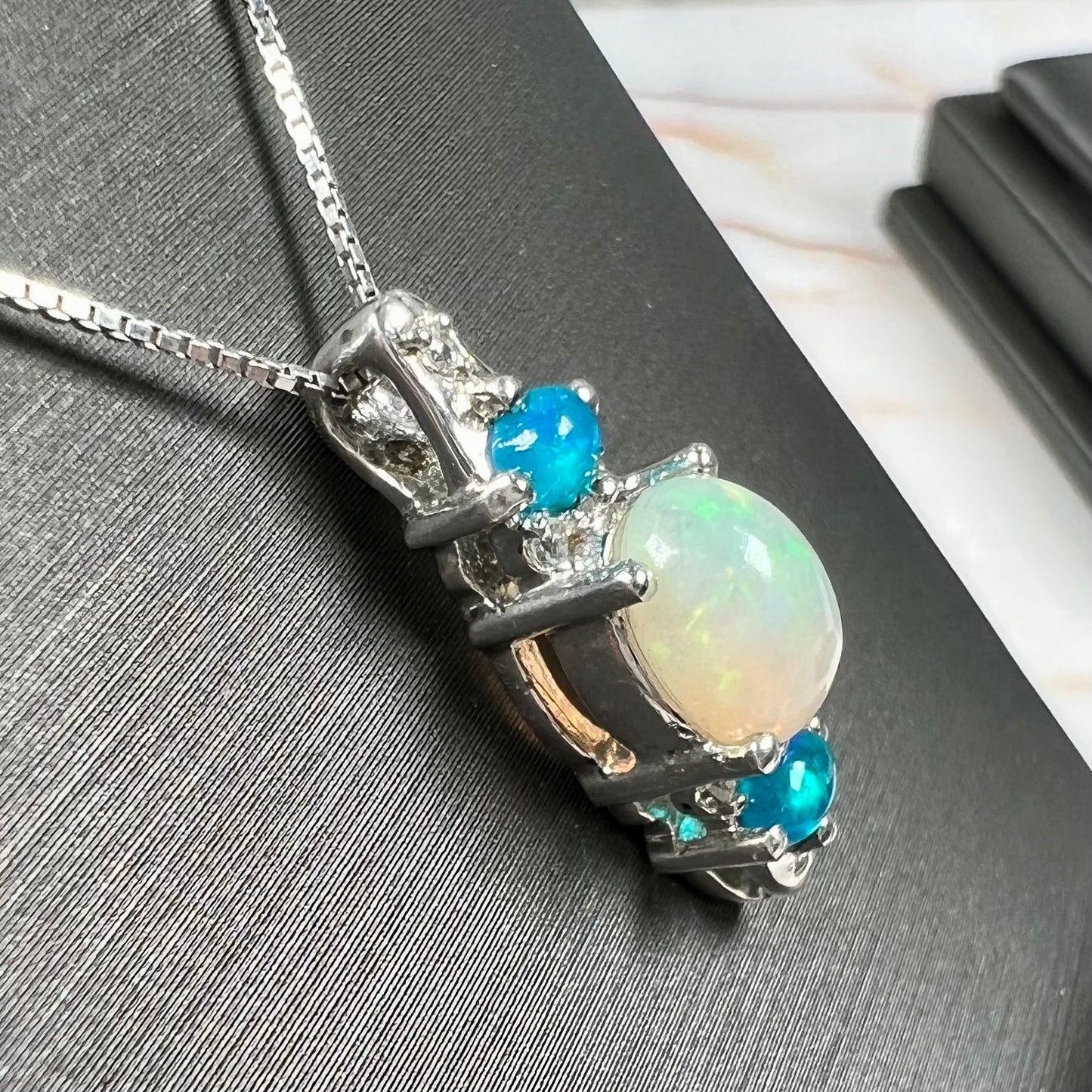 A sterling silver ring, earring, and necklace set made of Ethiopian opals and cubic zirconia.