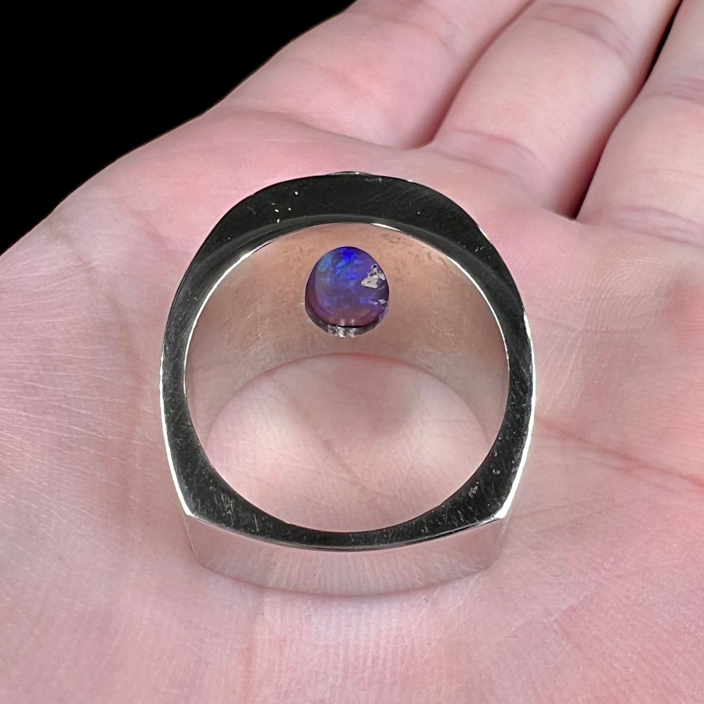 A men's natural black opal and diamond ring cast with a matte finish in white gold.