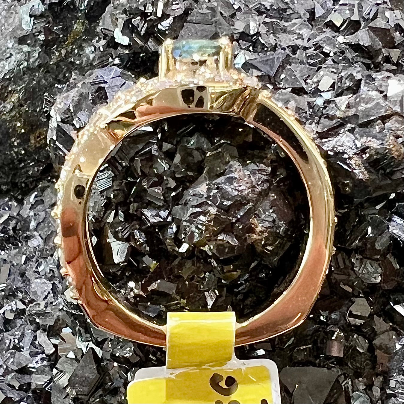 Yellow gold alexandrite and pave set diamond ladies' ring resting on a hematite crystal.