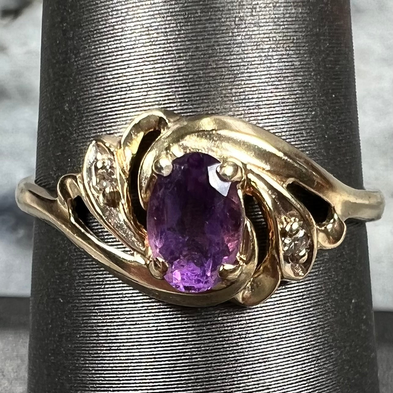 A yellow gold oval cut amethyst and diamond accent ladies' ring.