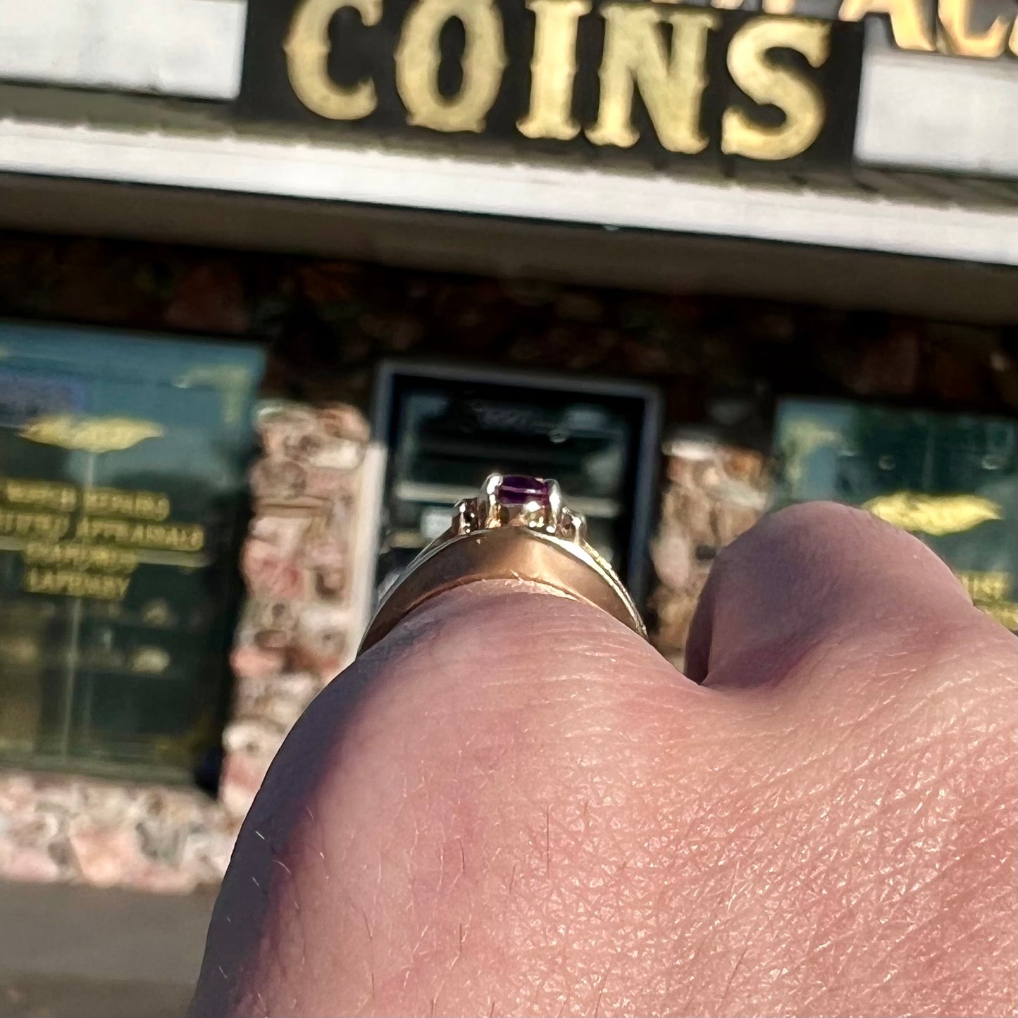 A ladies split shank gold ring set with an oval cut amethyst and round brilliant diamond accents.
