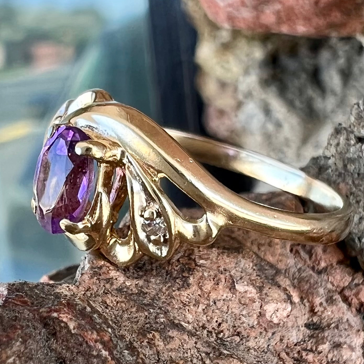 A yellow gold oval cut amethyst and diamond accent ladies' ring.
