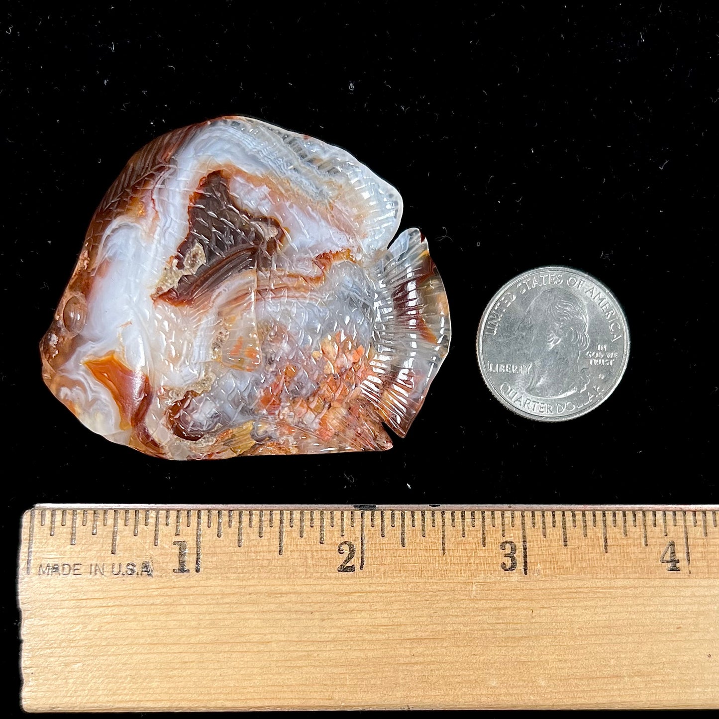 A stone fish carved from Northern Mexican fire agate.  The material is brown and white.