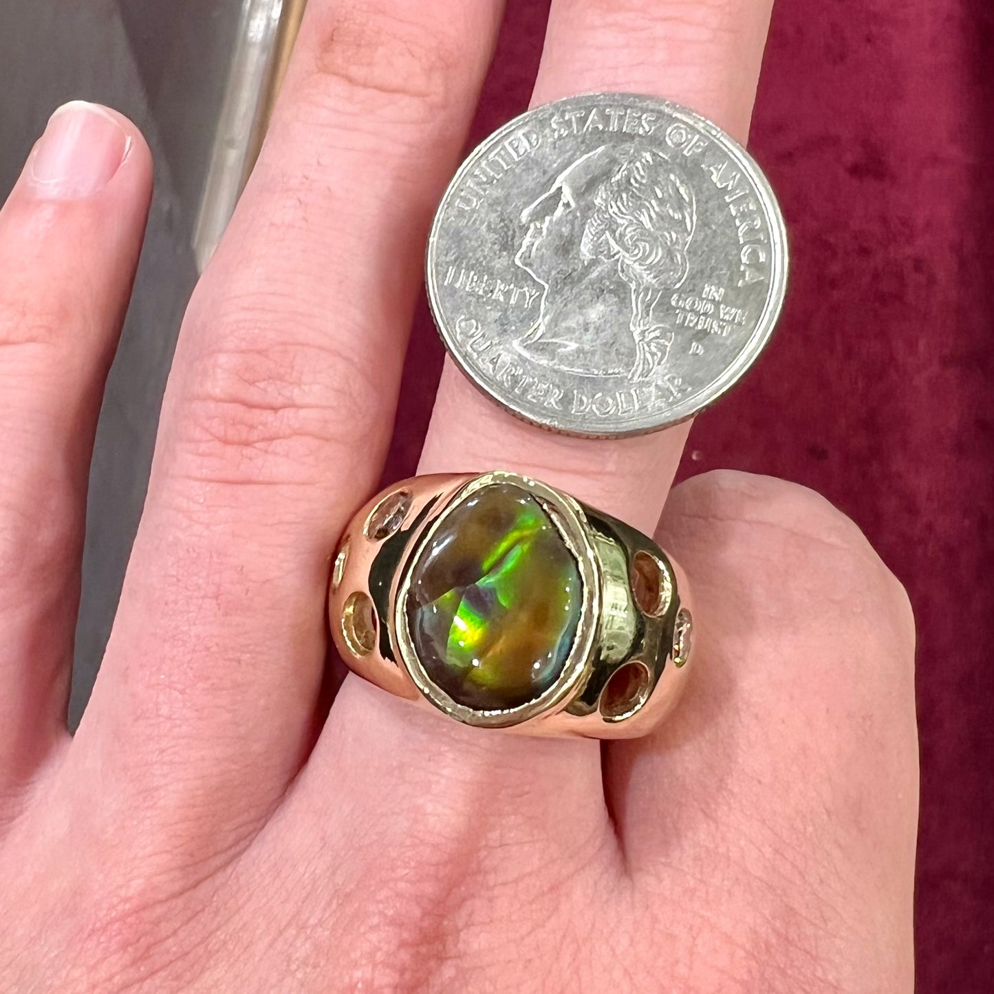 Men's rainbow fire agate ring set in yellow gold with champagne diamonds. The ring style has holes.