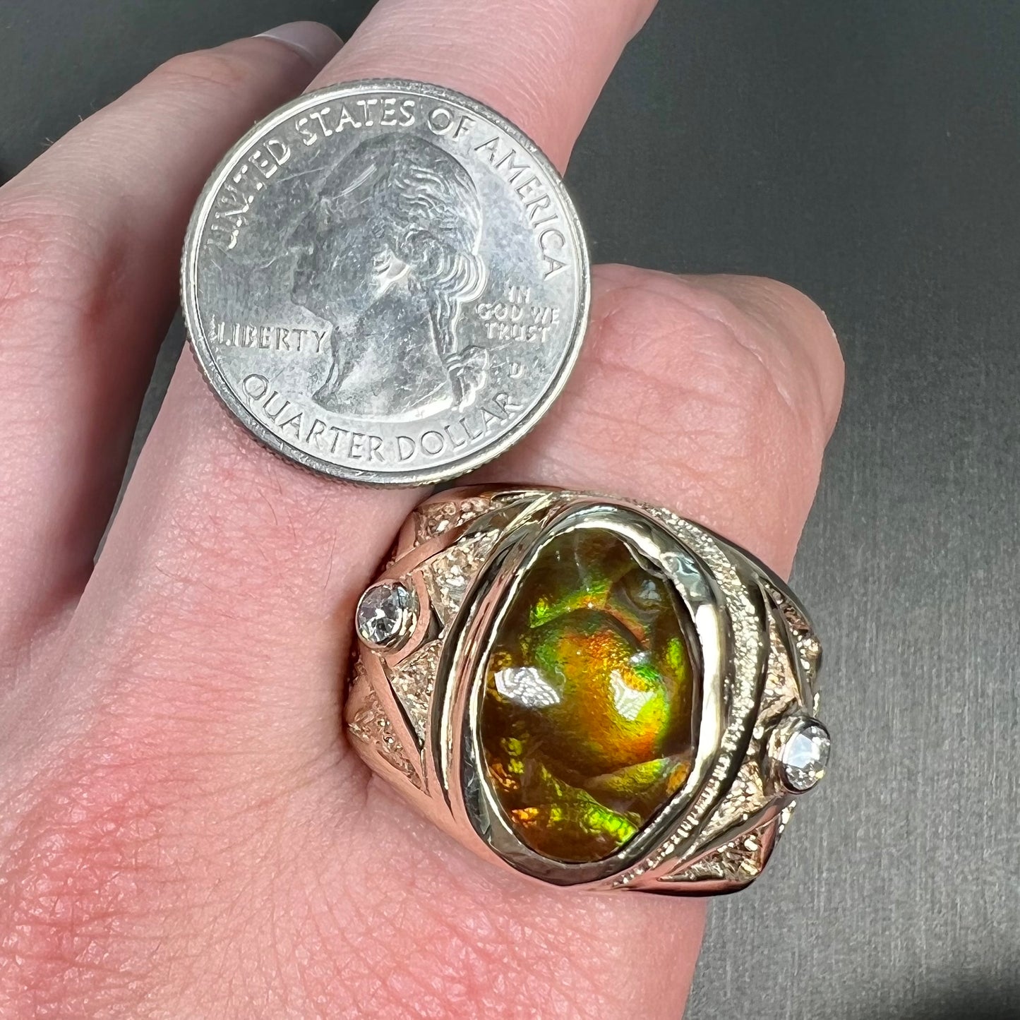 A men's solid yellow gold fire agate and diamond ring. The fire agate displays predominantly red and green.