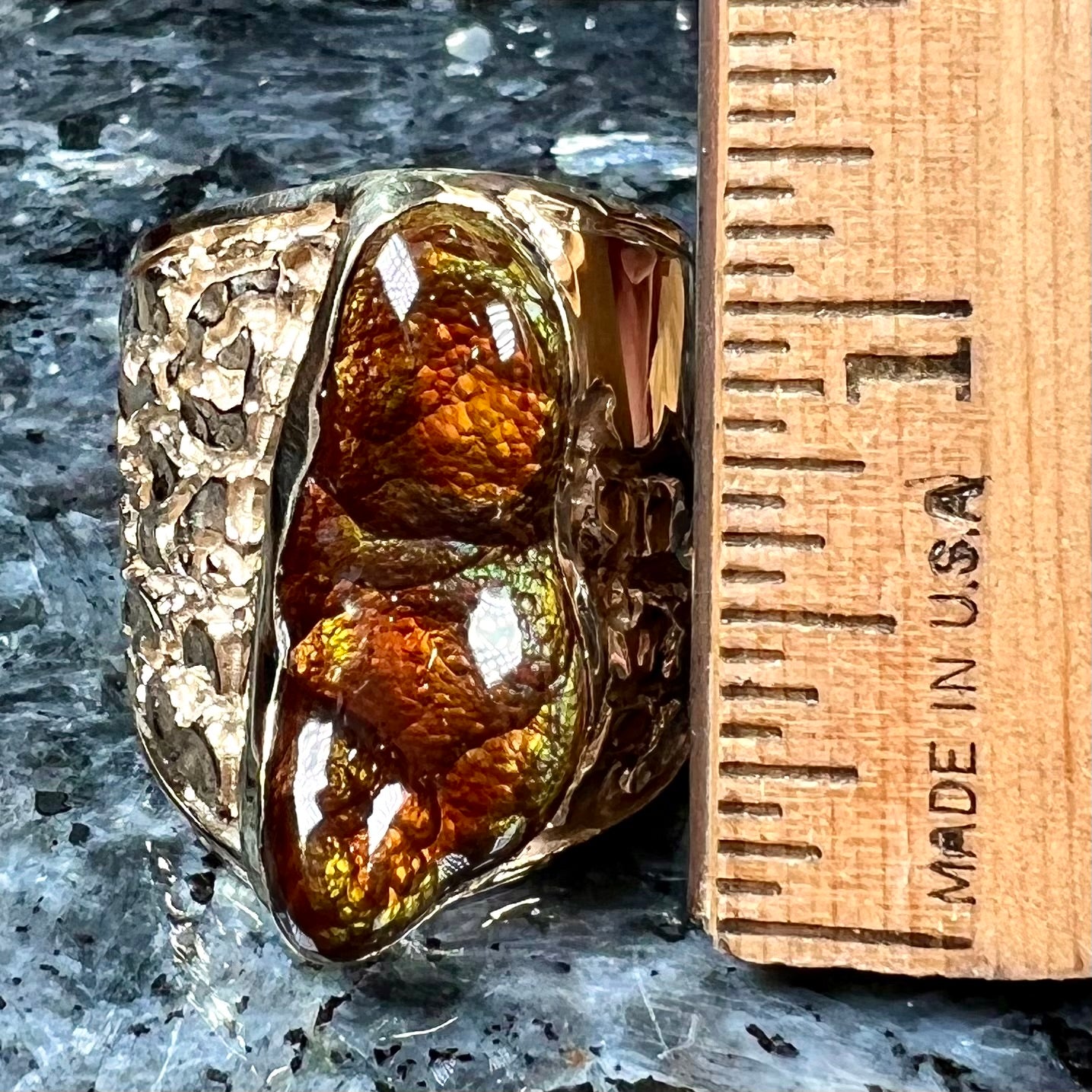 A large nugget style men's fire agate ring cast in yellow gold.  The fire agate is predominantly orange and green.