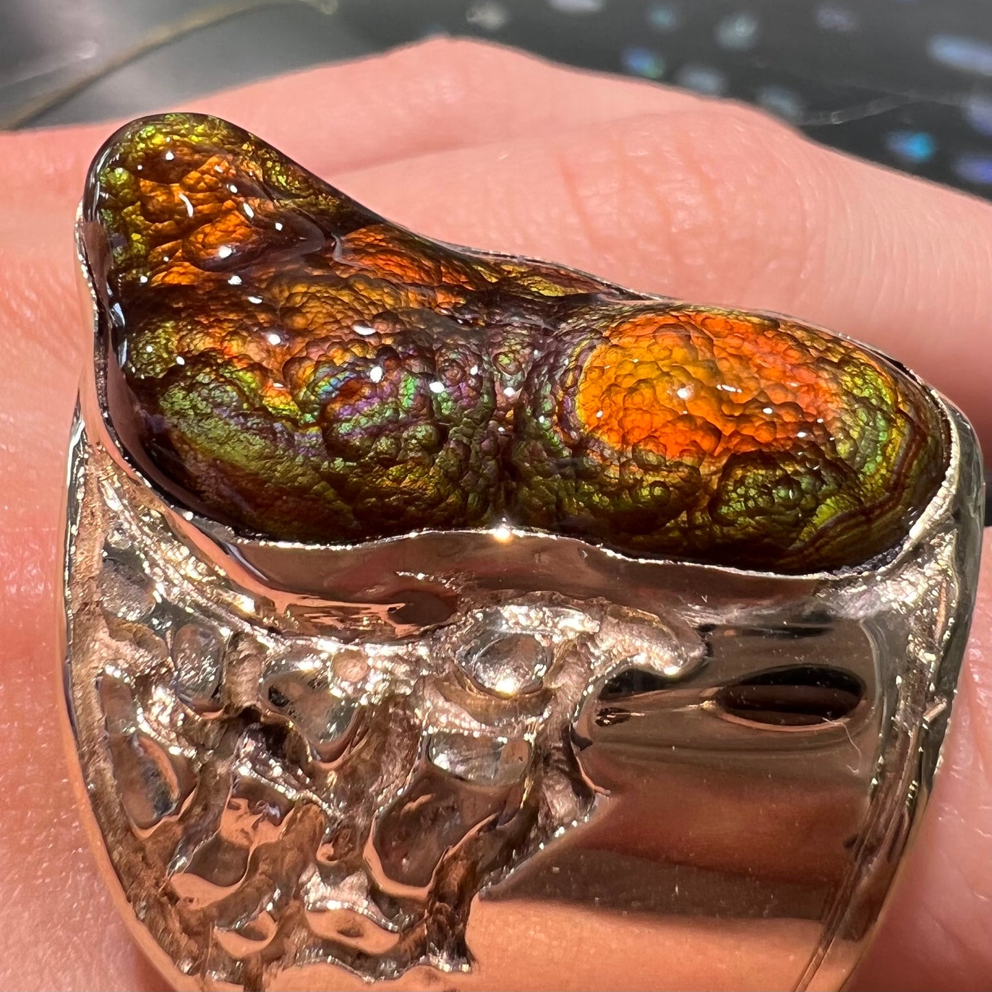 A large nugget style men's fire agate ring cast in yellow gold.  The fire agate is predominantly orange and green.