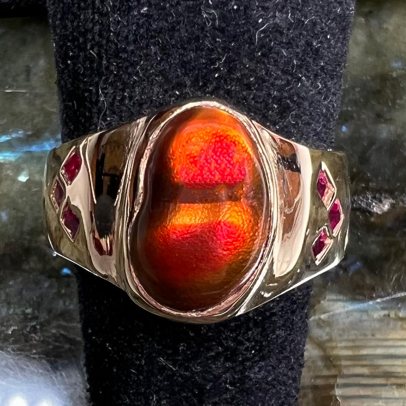 A yellow gold men's ring set with princess cut Burma rubies and a freeform cabochon cut red fire agate from Slaughter Mountain, Arizona.