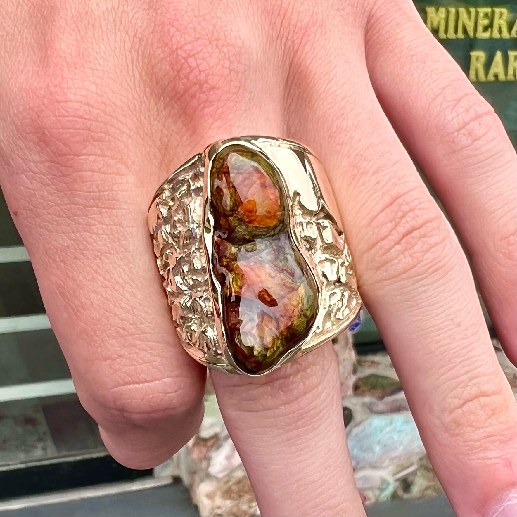 A large nugget style men's fire agate ring cast in yellow gold.  The fire agate is predominantly orange and green.