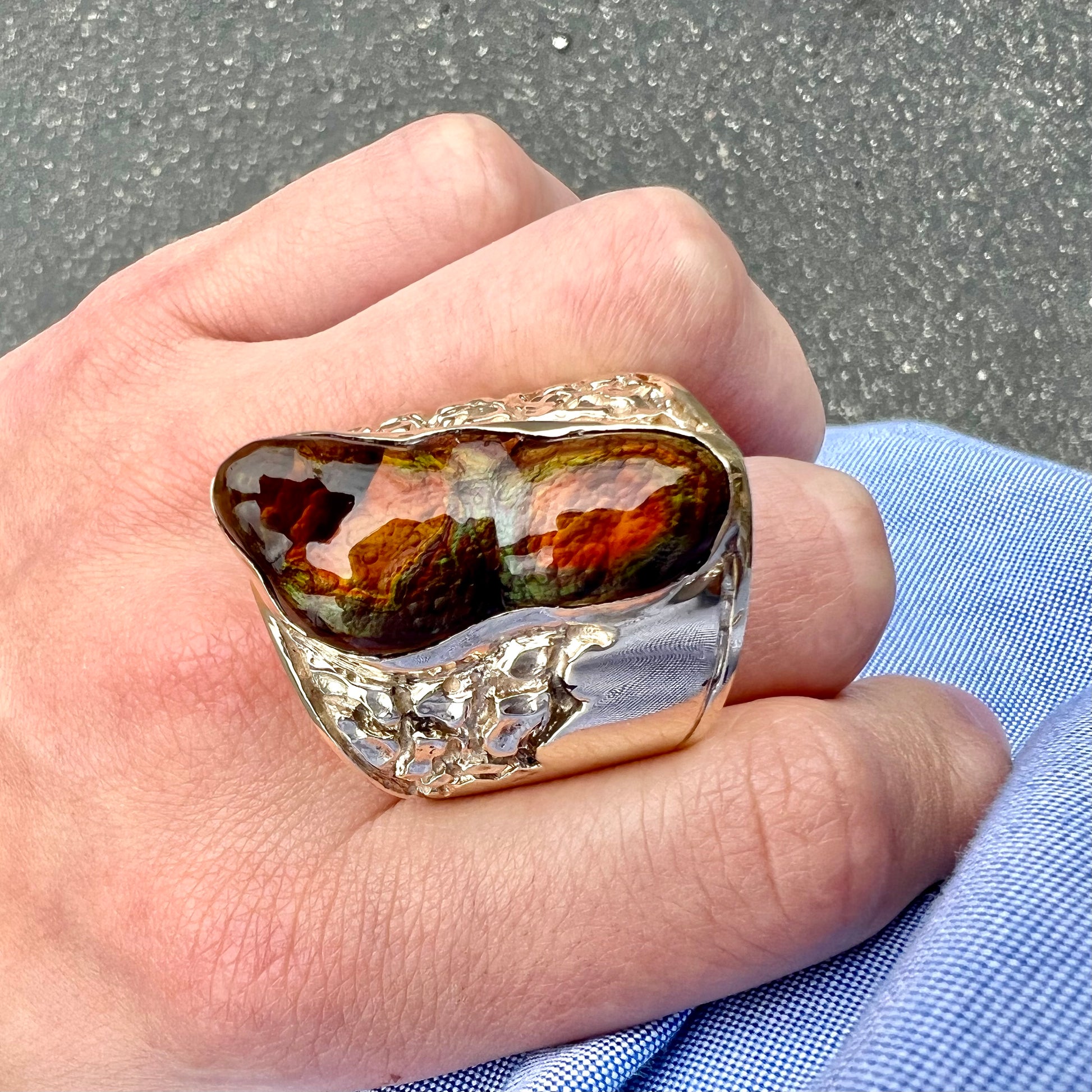 A large nugget style men's fire agate ring cast in yellow gold.  The fire agate is predominantly orange and green.