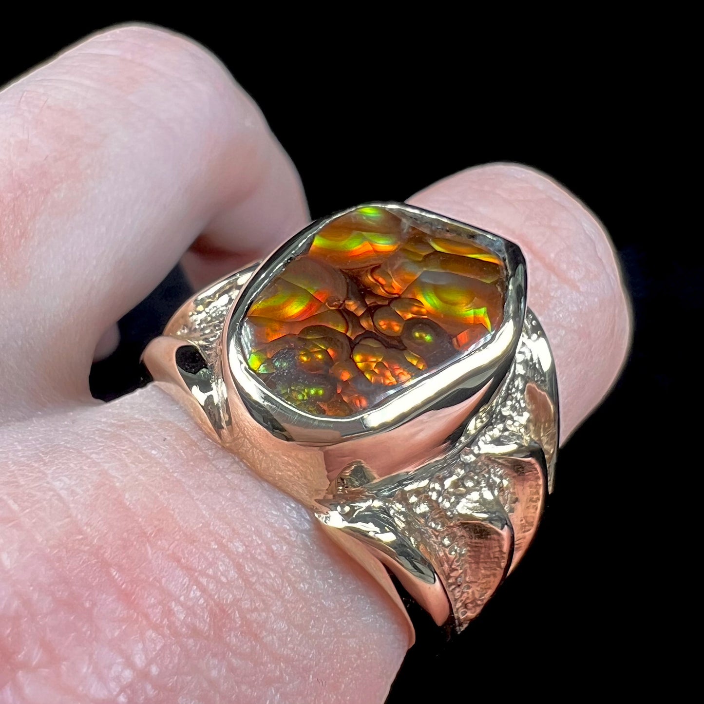 A men's yellow gold fire agate solitaire ring. The stone has a botryoidal pattern with sagenite inclusions.