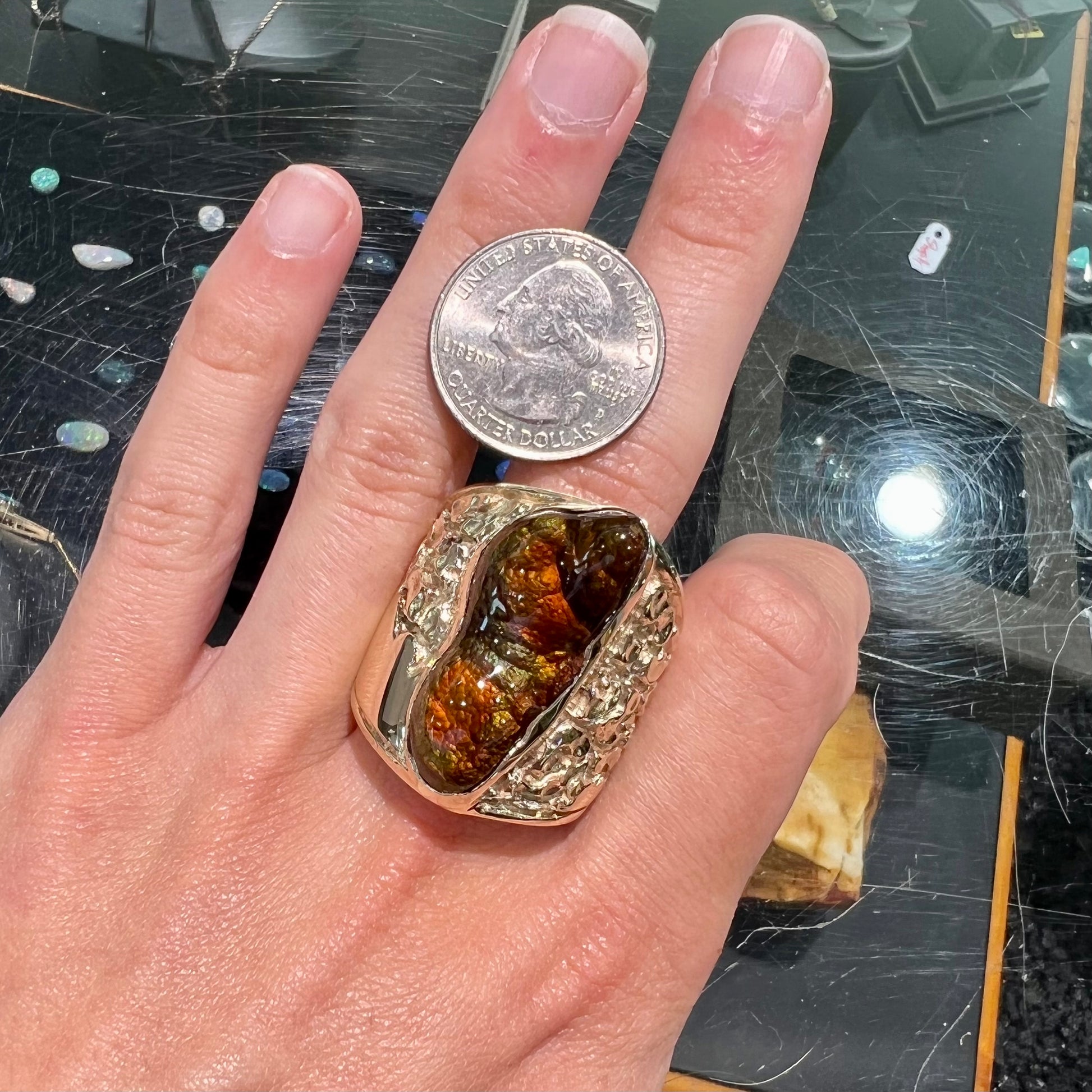 A large nugget style men's fire agate ring cast in yellow gold.  The fire agate is predominantly orange and green.
