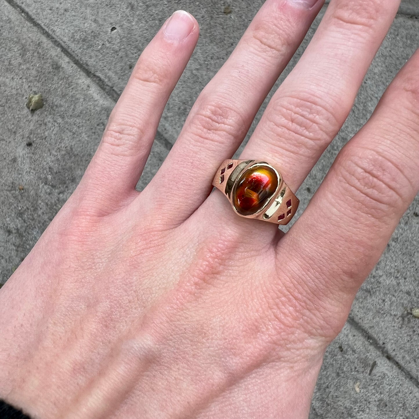 A yellow gold men's ring set with princess cut Burma rubies and a freeform cabochon cut red fire agate from Slaughter Mountain, Arizona.