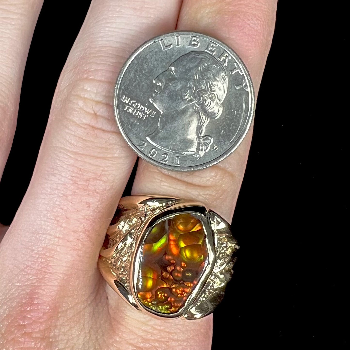 A men's yellow gold fire agate solitaire ring. The stone has a botryoidal pattern with sagenite inclusions.