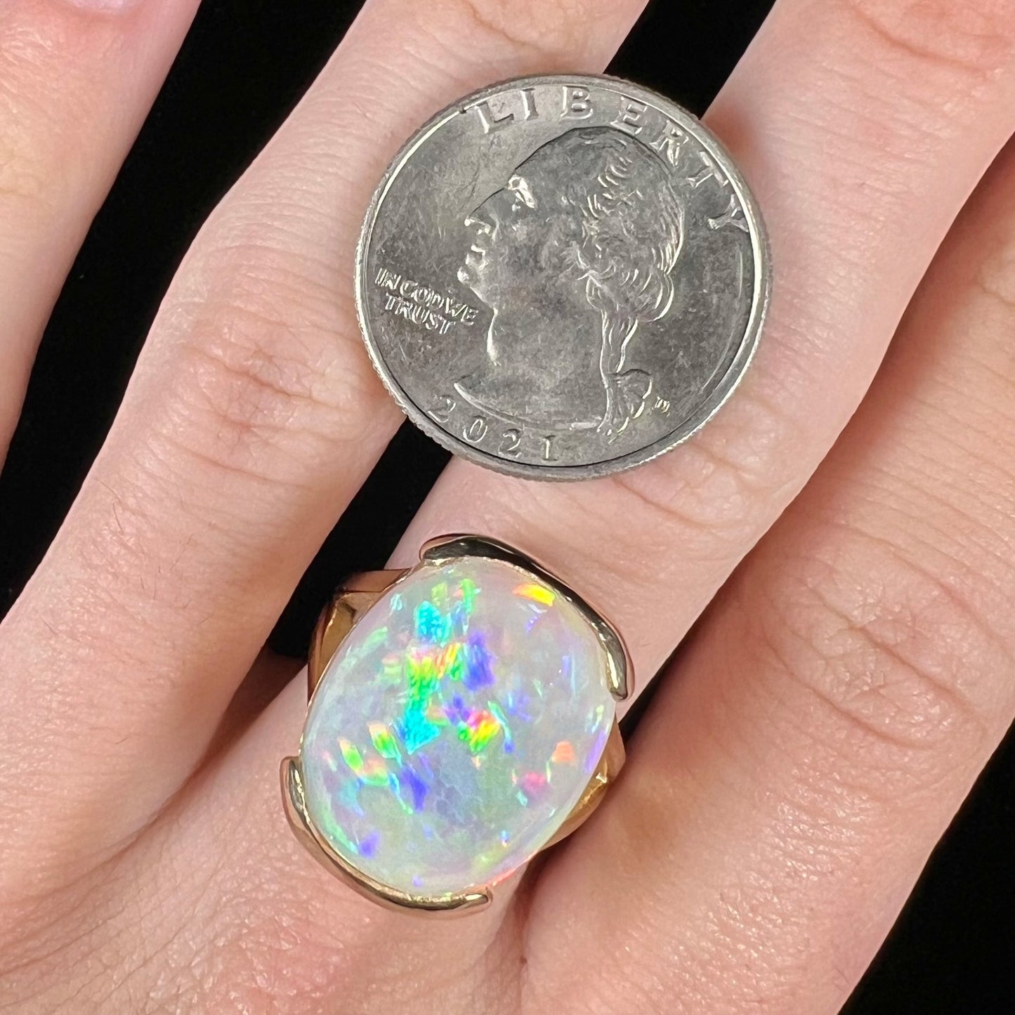 A ladies' yellow gold split shank ring half-bezel set with a barrel cabochon cut natural Ethiopian fire opal stone.