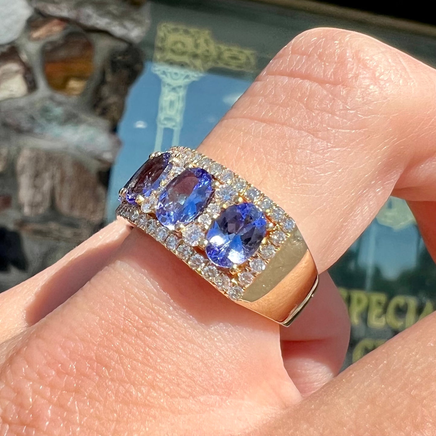 A gold and diamond ladies' band set with five oval cut tanzanite stones.