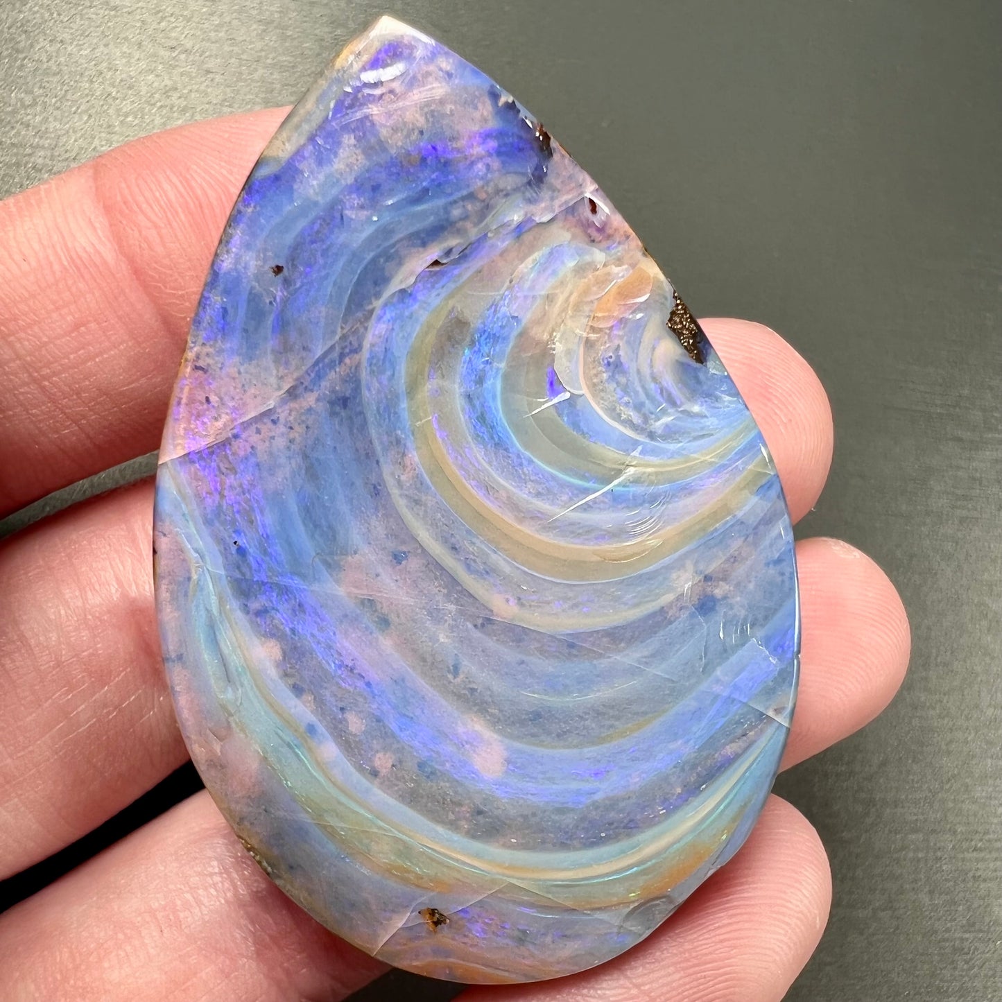 A loose, polished Quilpie boulder opal stone from Queensland, Australia. The opal displays a blue flow pattern.