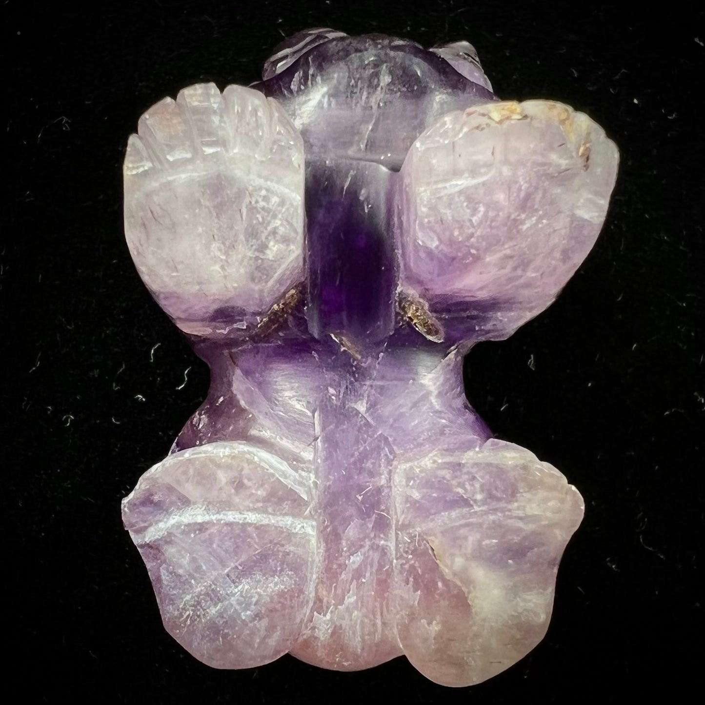 A stone foo dog carving carved from a purple Brazilian amethyst crystal.